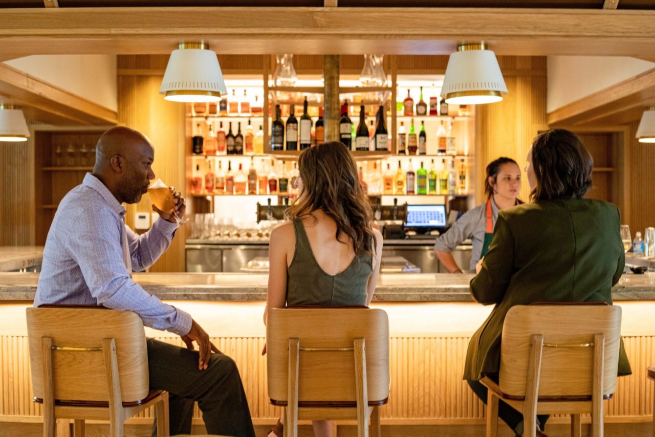 Three people enjoying drinks at Five Nines' Denver cocktail bar