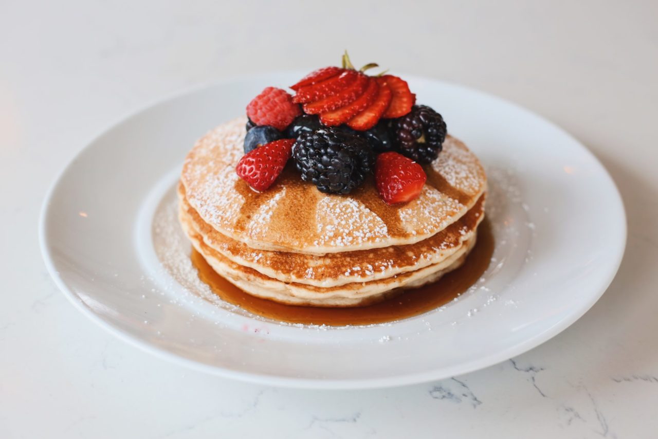 Pancakes with syrup, berries, and sugar at our Cherry Creek restaurant