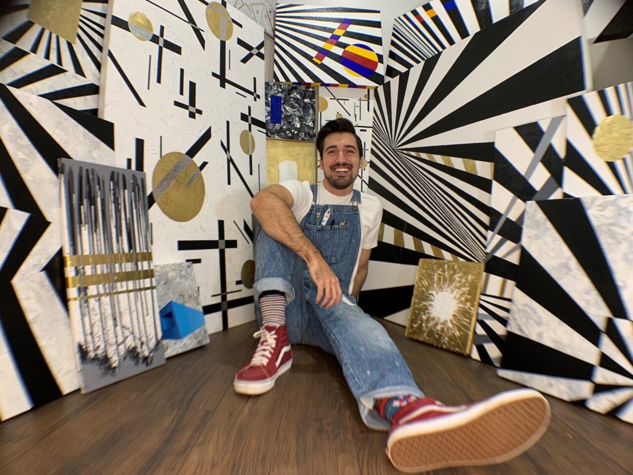 Man in overalls smiling among geometric art at our boutique Denver hotel