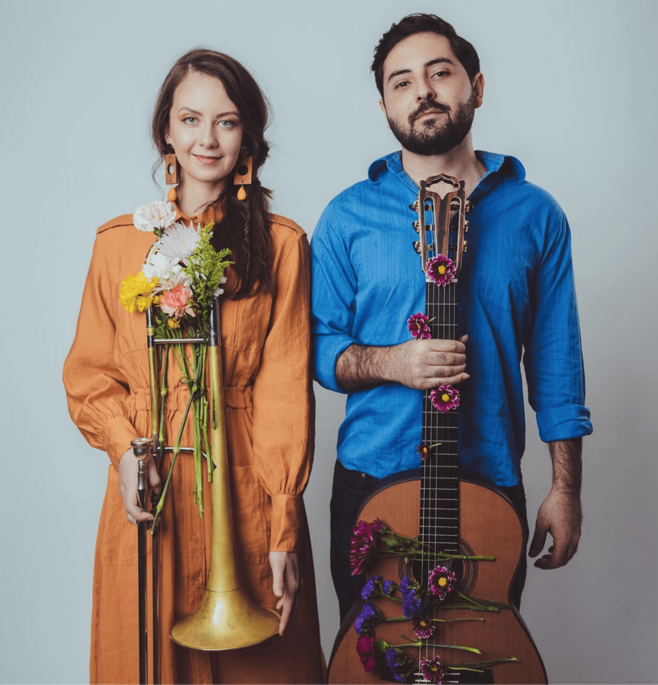 Couple holding instruments decorated with flowers at our Denver hotel