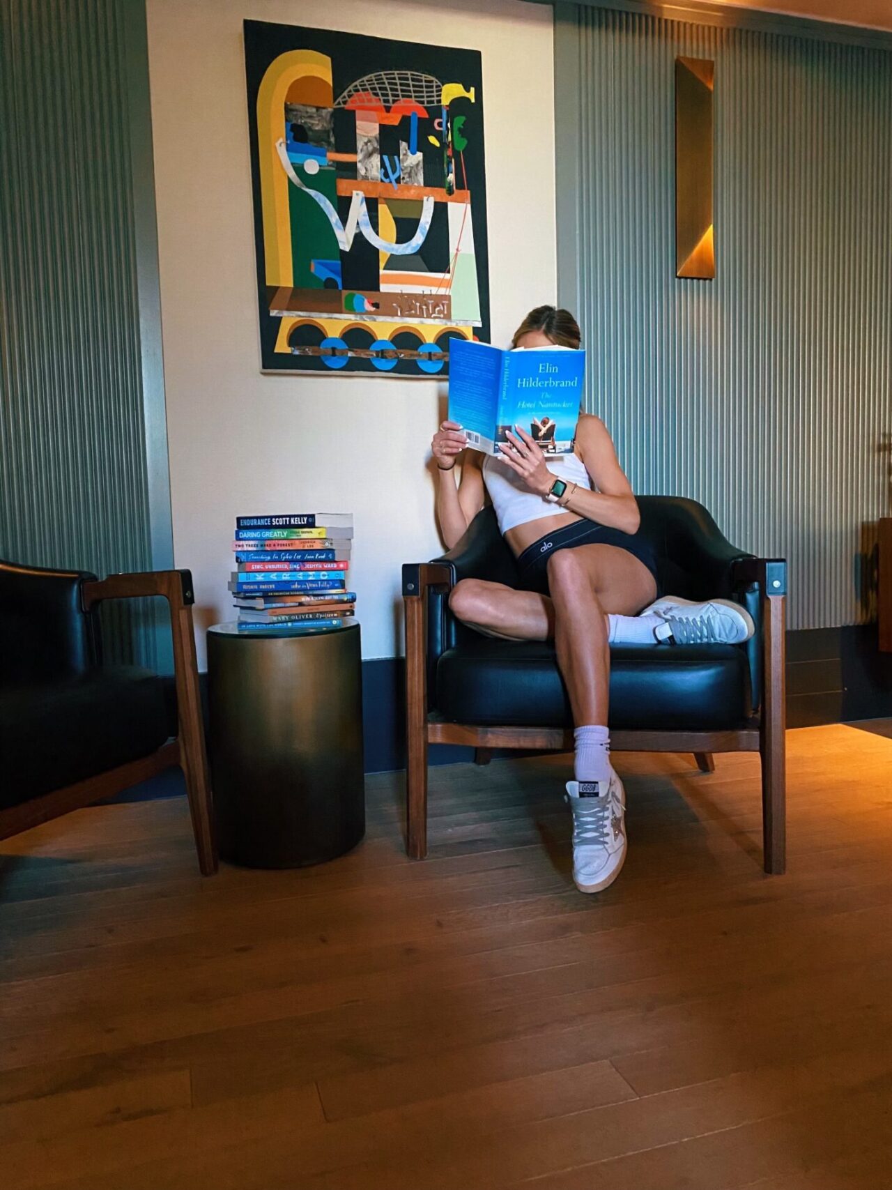 Woman covering her face with a book at our hotel in Cherry Creek, CO