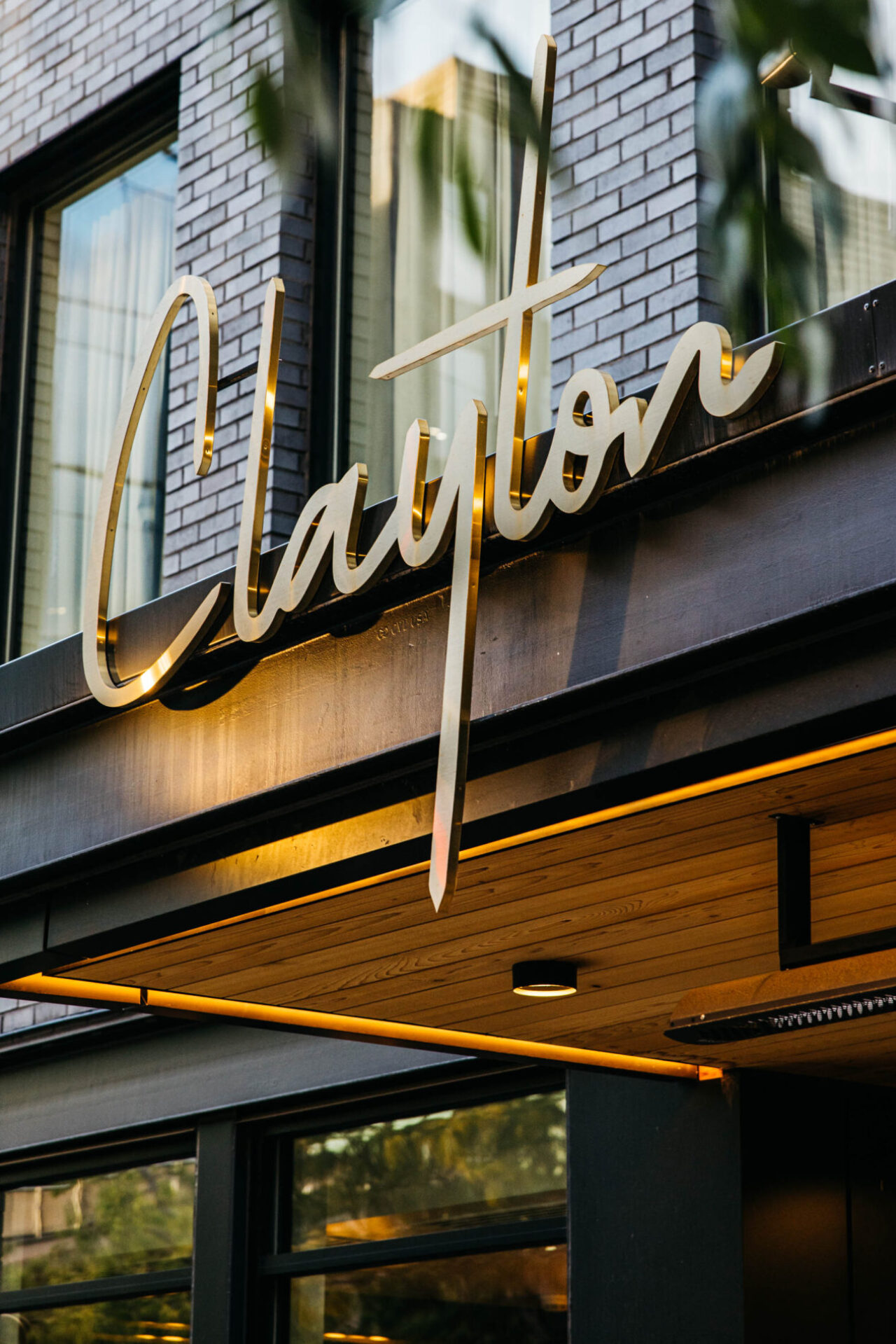 Golden exterior sign for Clayton, our Cherry Creek boutique hotel